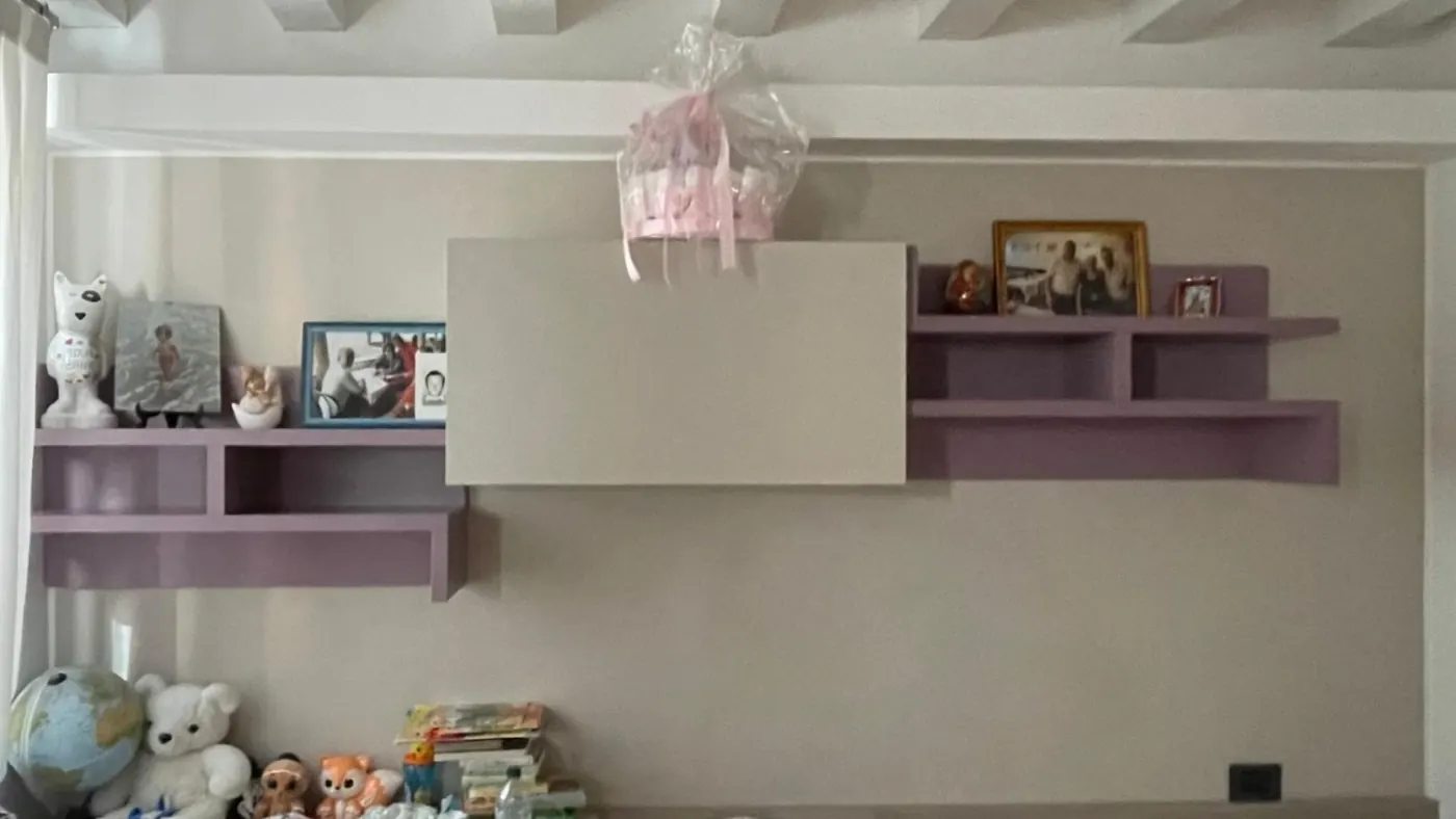 Camera da letto con parete beige e mensole lilla, prima della tinteggiatura